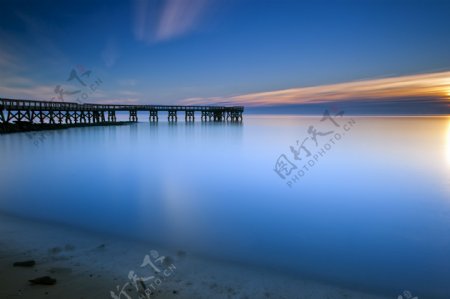落日下海岸木桥图片