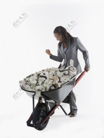 微笑的女人推着装满钞票的推车图片