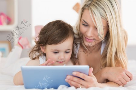 陪孩子玩平板电脑的女人图片