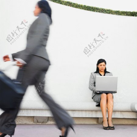 打电脑与行走在路上的女人图片