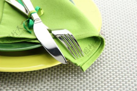 绿色桌布上的刀叉图片