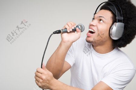 戴耳麦拿话筒唱歌的男人图片