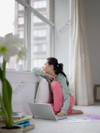 坐在窗边上网的女人图片
