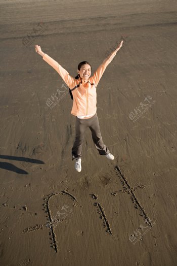 沙滩上跳跃的人物摄影图片