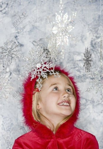 看圣诞雪花挂饰的甜蜜小女孩图片