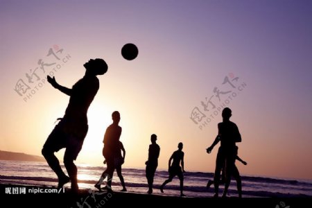 沙滩上打橄榄球的人们图片