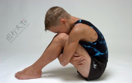 穿体操服抱腿而坐的男孩图片