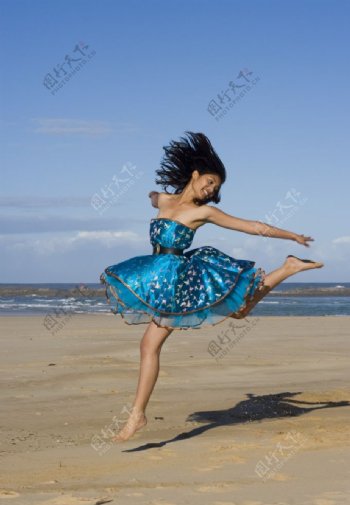 沙滩上跳跃的美女图片