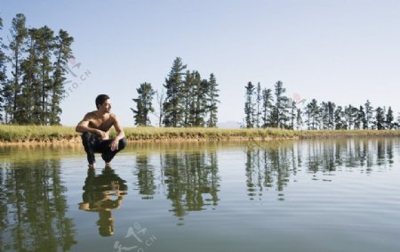 蹲在水面上的男人图片