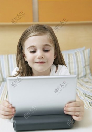床上看笔记本电脑的可爱小女孩图片