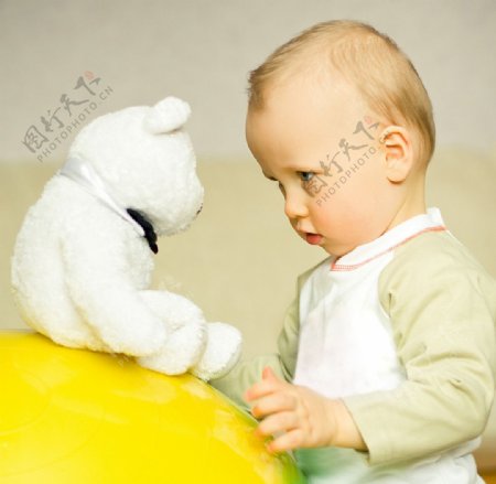 和玩具熊玩耍的婴儿宝宝图片