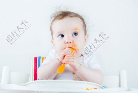 拿着勺子在吃东西的婴儿图片