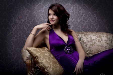 坐在沙发上的紫裙美女图片