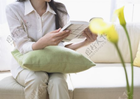 坐在沙发上看书的休闲美女