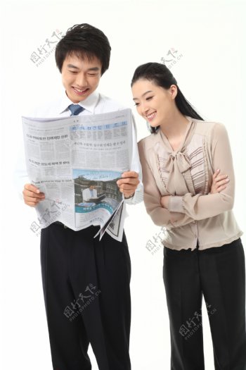 看报纸微笑的商务男女图片