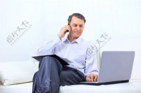 看电脑打电话的商务男人图片