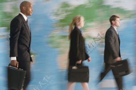 世界地图前行走的外国商务人士图片