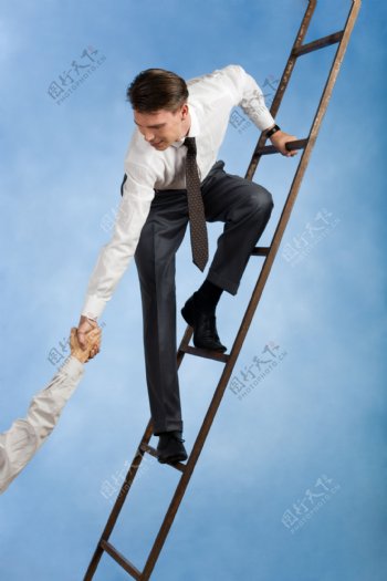 一起爬梯子的商务人士图片
