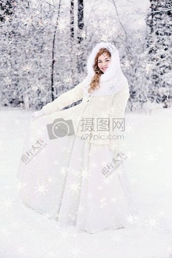 女性在白雪西装站在白雪覆盖的地面覆盖树雪的背后