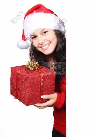女性在白色和红色的圣诞帽控股红色的圣诞礼物