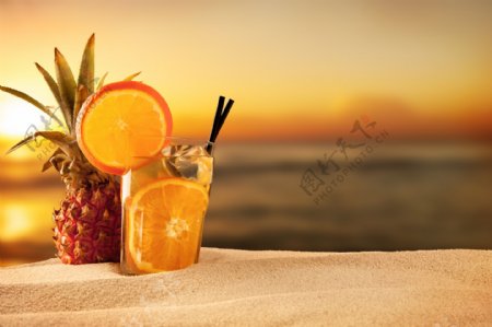 沙滩上的菠萝与柠檬汁图片