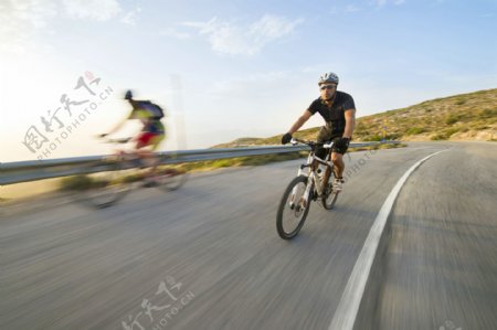 公路上骑着单车的人物图片