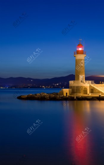 夜晚海面上的的的灯塔摄影图片