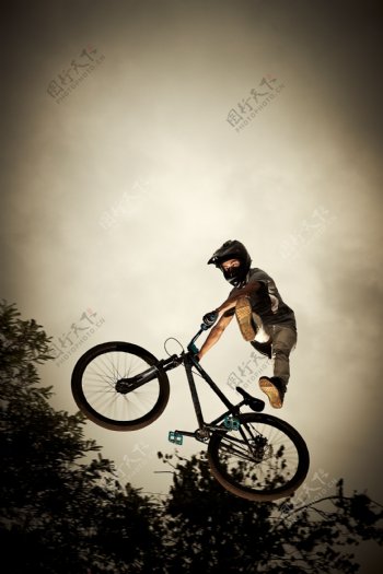 自行车上跳起的运动员图片