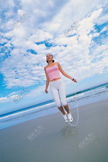 沙滩上跳绳的美女图片