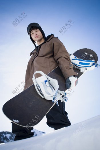 手抱滑雪板的男孩图片