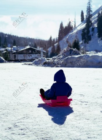 坐在雪橇上的小男孩