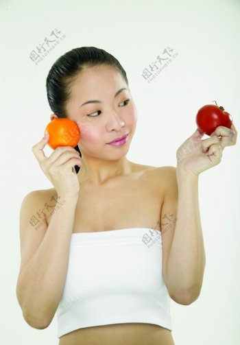手拿橙子蕃茄的美女图片