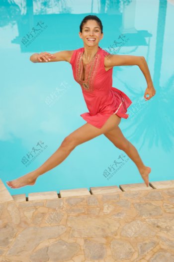 水池边跳跃的美女图片