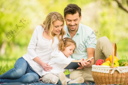 草坪上看书的幸福家庭图片
