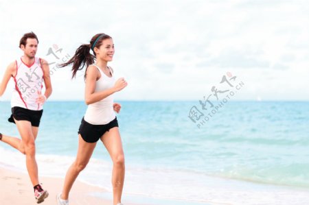 海边沙滩上跑步的外国情侣图片