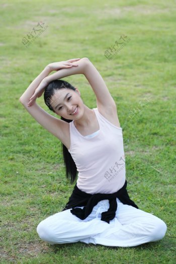 坐在草地上做瑜伽的运动少女图片图片