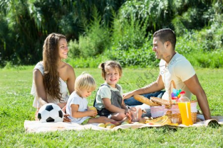 坐在草地上野餐的幸福家庭图片