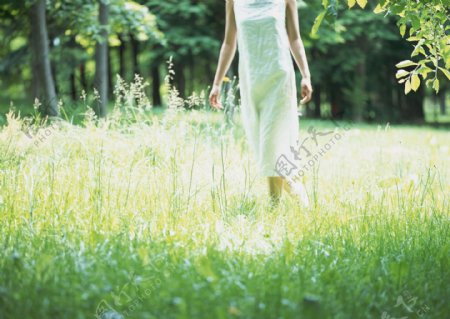 行走在草丛中的女性图片