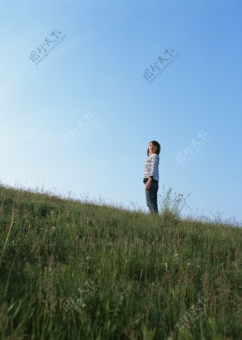 站立在草地上的女人图片