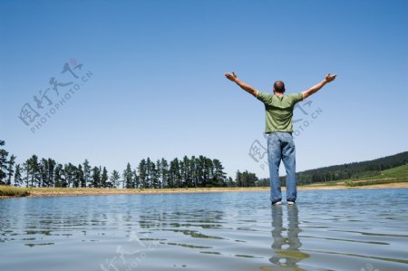 双手展开站在水面上的男人图片