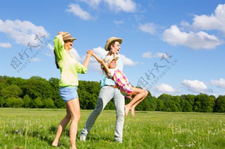 草地上开心跳跃的一家人图片