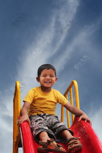 开心滑滑梯的小男孩图片