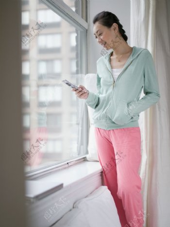窗边接电话的休闲女人图片
