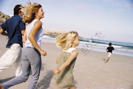 奔跑在沙滩上的幸福家庭图片