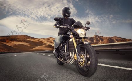 骑摩托车在公路上行驶的男人图片