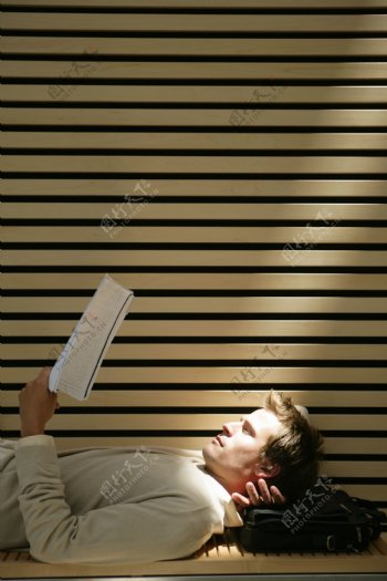 躺在椅子上看书的外国男人图片