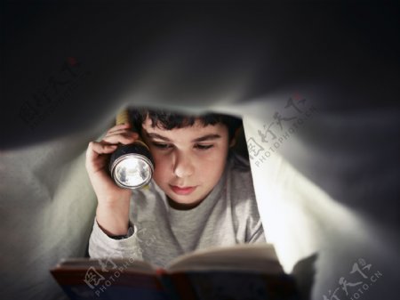 拿着手电筒看书的孩子图片