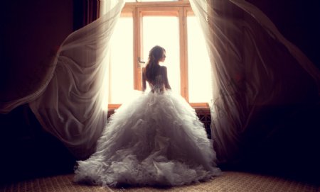 穿着婚纱向窗外望去的外国美女图片