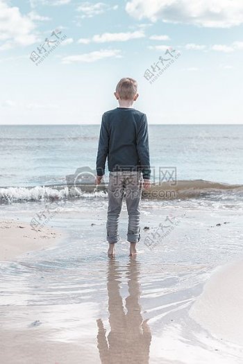 站在海滩上的小男孩