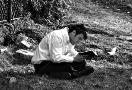 在草地上读书的男人